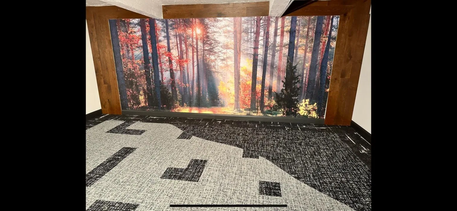 Geometric black and white commercial carpet beside forest mural