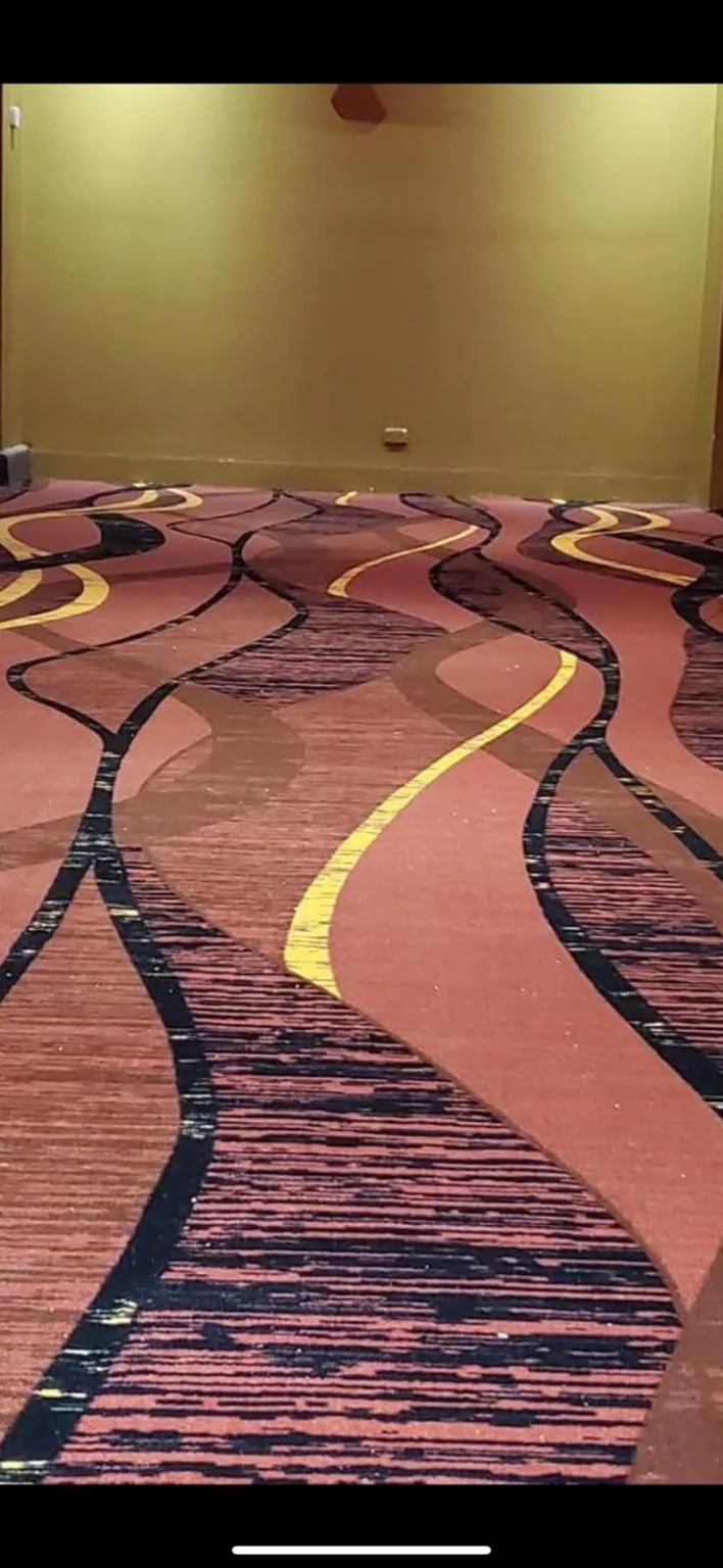 Custom burgundy carpet with abstract sweeping gold and dark lines